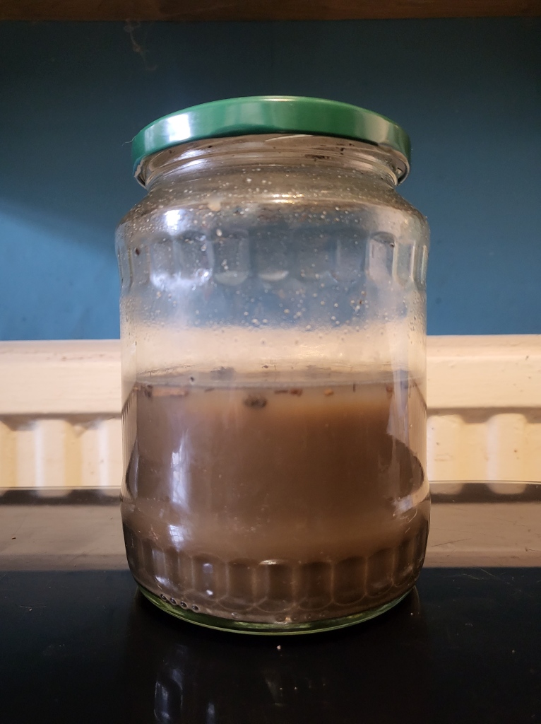 Jar of soil & water mixed together.